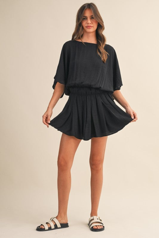Woman wearing a black outfit on a beige background