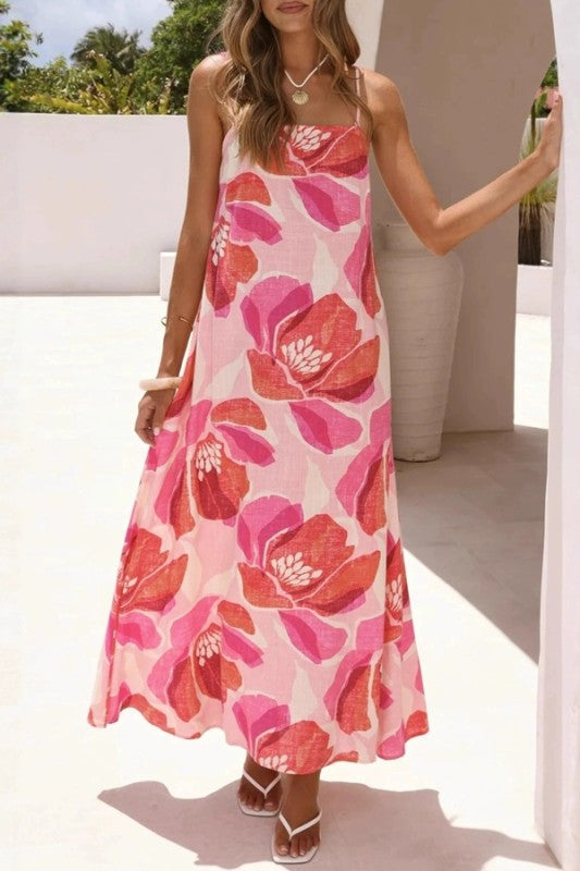 Woman wearing a pink floral dress standing outdoors.