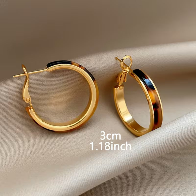 Gold hoop earrings with a tortoiseshell patterned inlay, displayed on a beige satin fabric background with a size text overlay reading '3cm 1.18inch'.