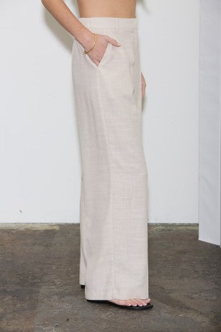 Person wearing light-colored wide-leg pants against a plain background