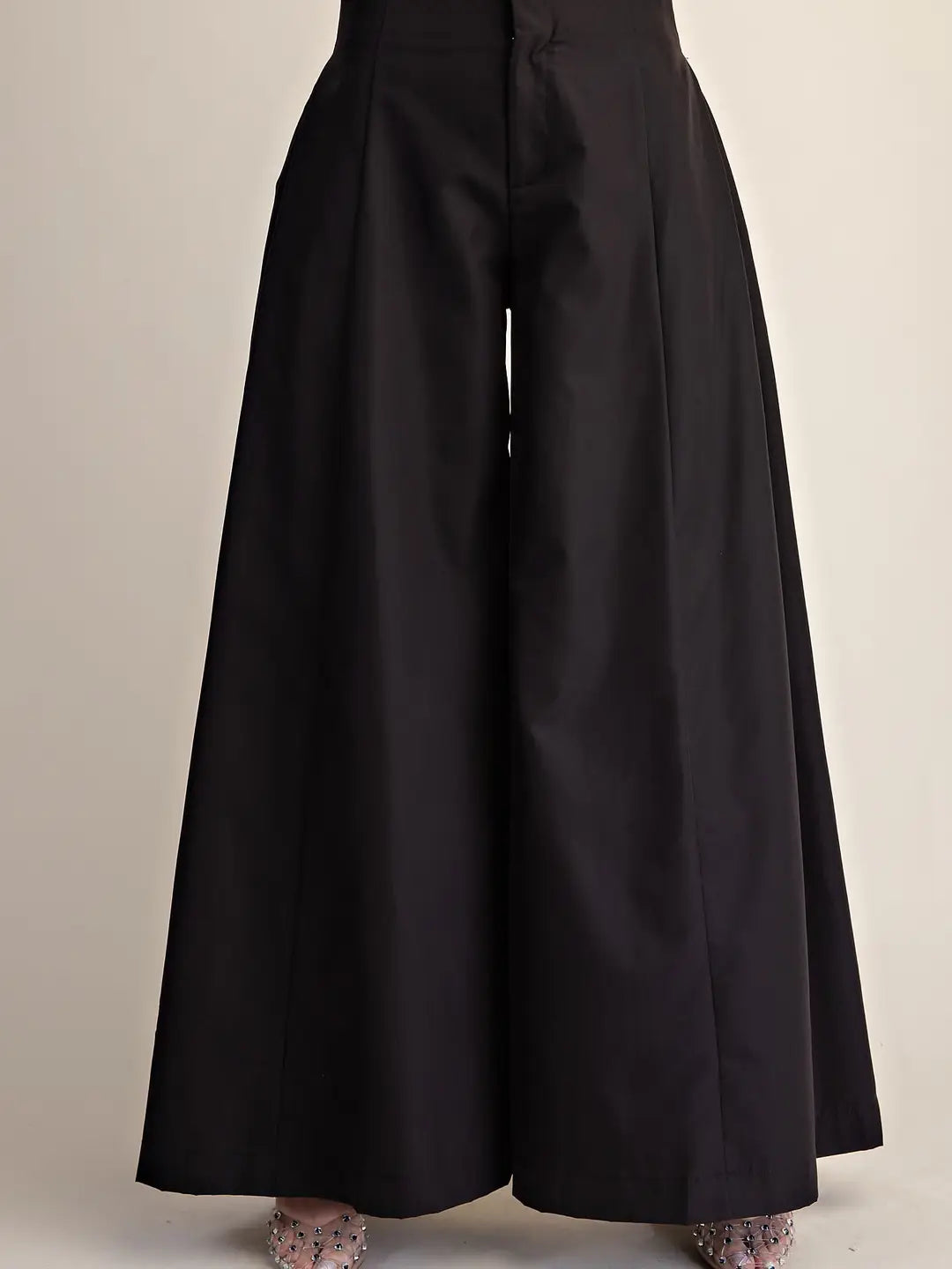Black wide-leg cropped trousers with a high waist and front button closure, shown on a model from the waist down against a plain light beige background.