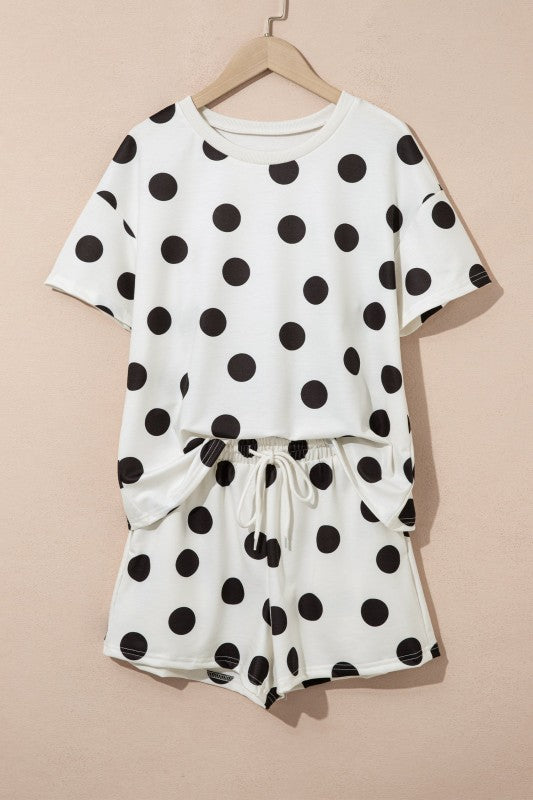 White outfit with black polka dots on a beige background