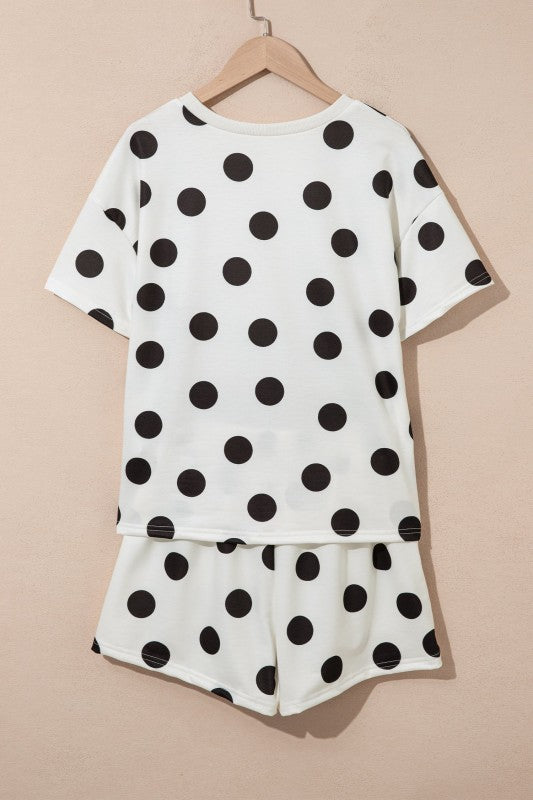 White outfit with black polka dots on a beige background