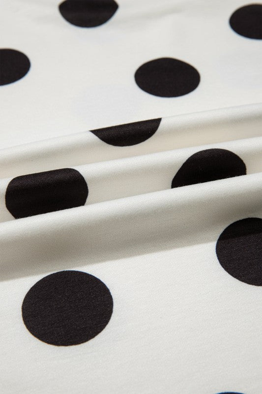 Close-up of fabric with large black polka dots on a white background