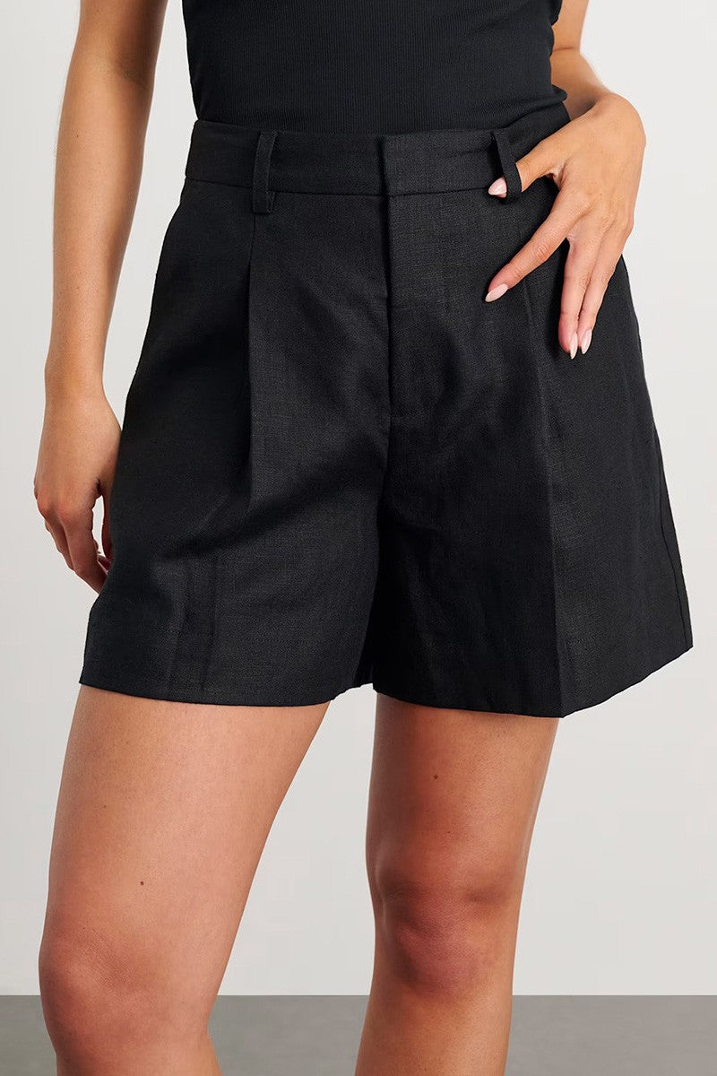 Person wearing black shorts on a plain background