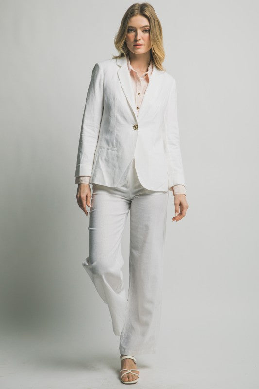 Woman wearing a white suit on a plain background