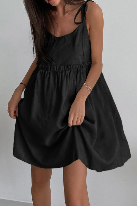Black dress worn by a person against a plain background