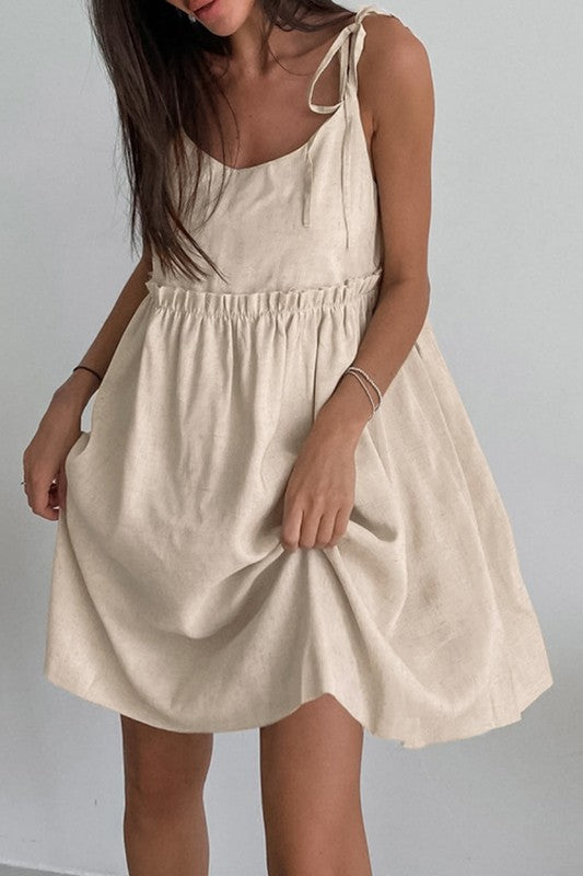 Beige dress worn by a person on a plain background