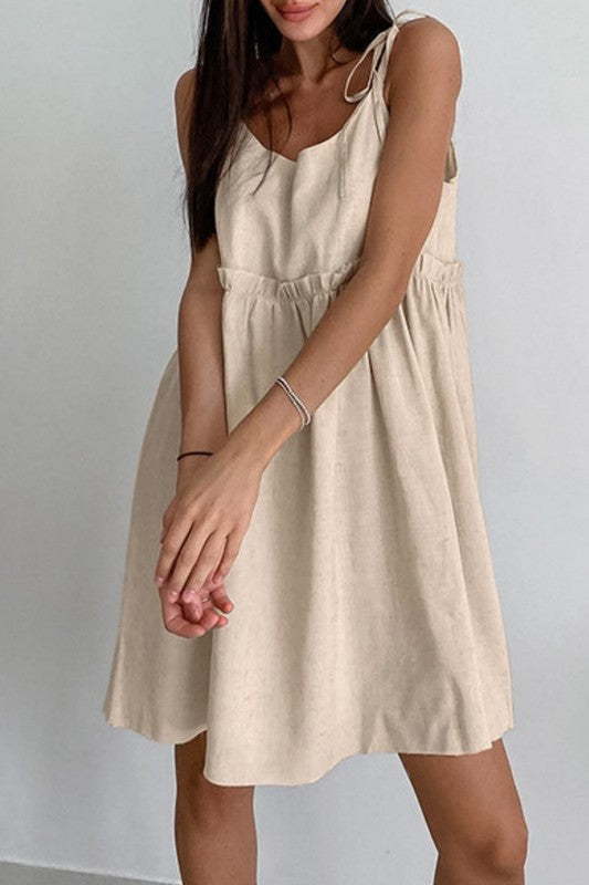 Woman wearing a beige dress against a white background