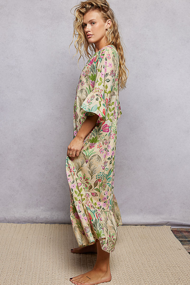 Woman wearing a floral kimono-style dress against a plain background
