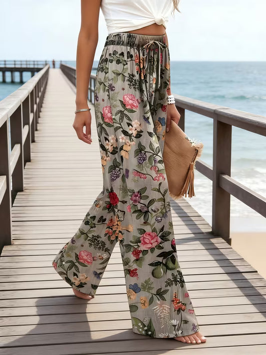 Person wearing floral pants on a wooden pier by the ocean