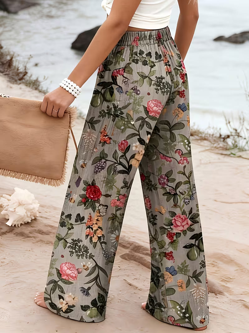 Floral patterned pants worn by a person on a beach.
