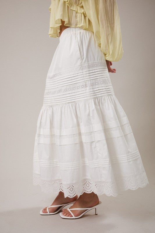 White lace skirt with a yellow blouse on a neutral background