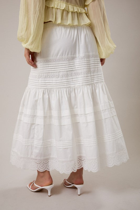 White lace skirt worn by a person on a plain background