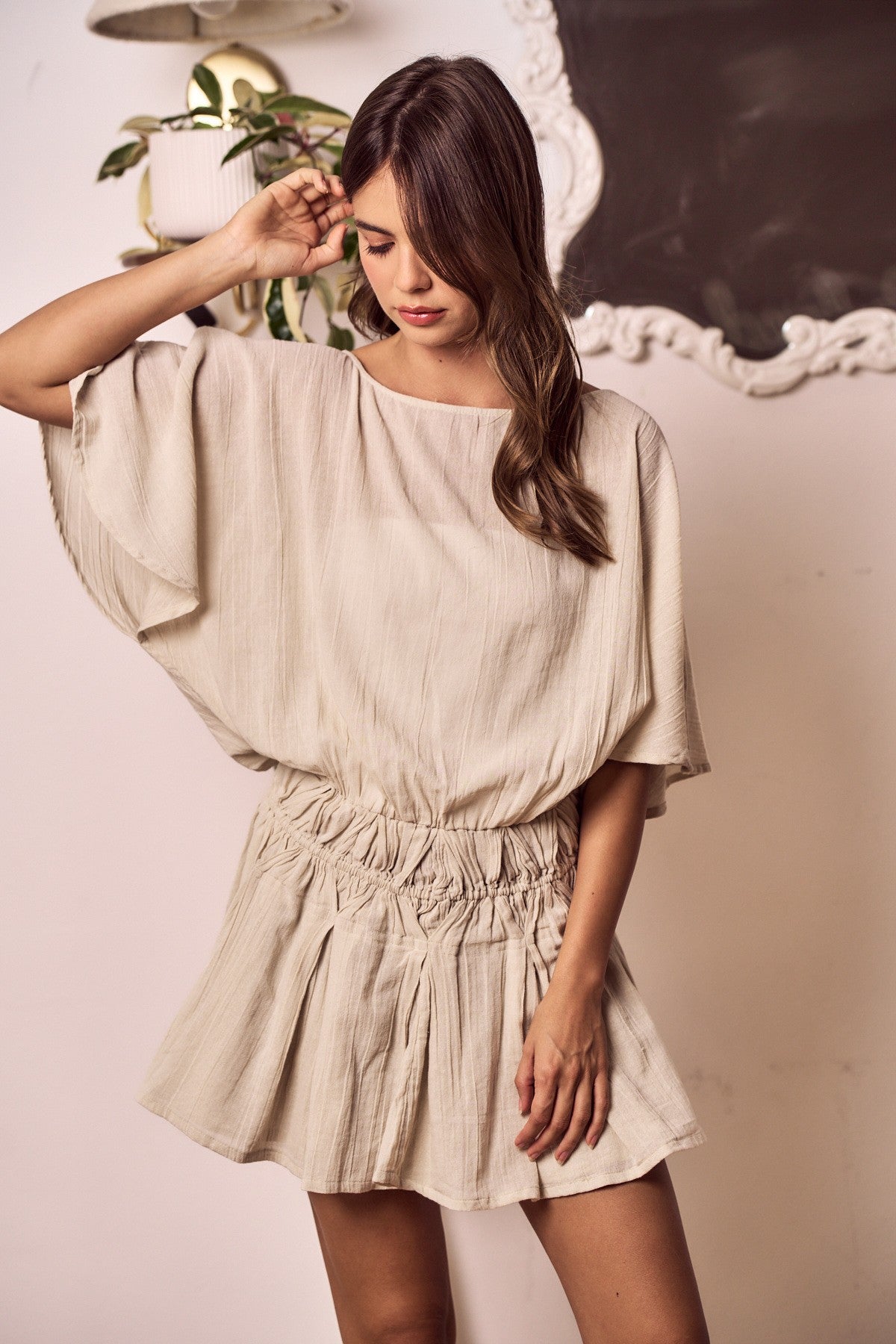 Woman wearing a beige dress with a neutral background
