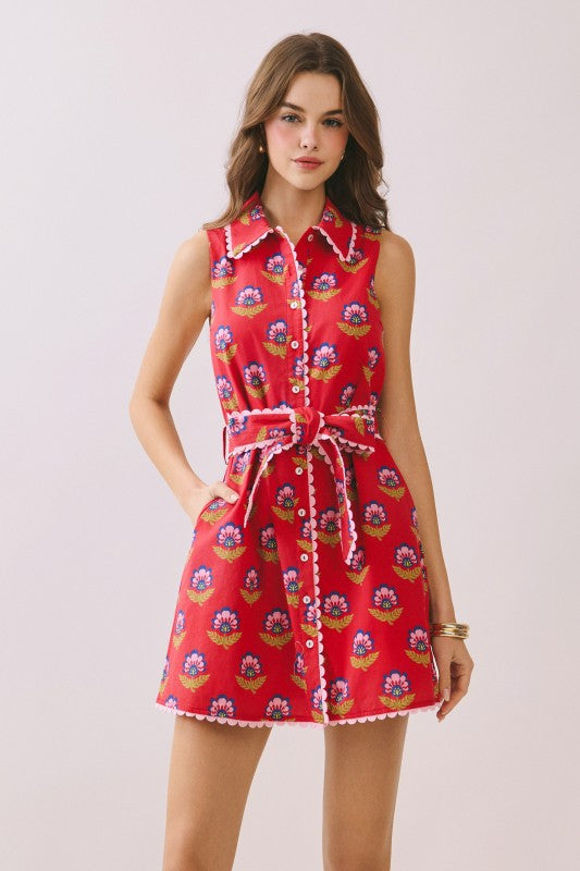 Woman wearing a red floral dress on a light pink background