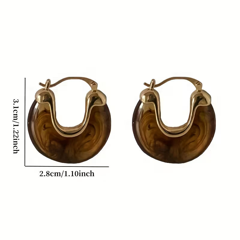 A pair of U-shaped hoop earrings with a marbled brown and amber resin body and gold-tone metal hoops, shown with dimension lines indicating a height of 3.1 cm and a width of 2.