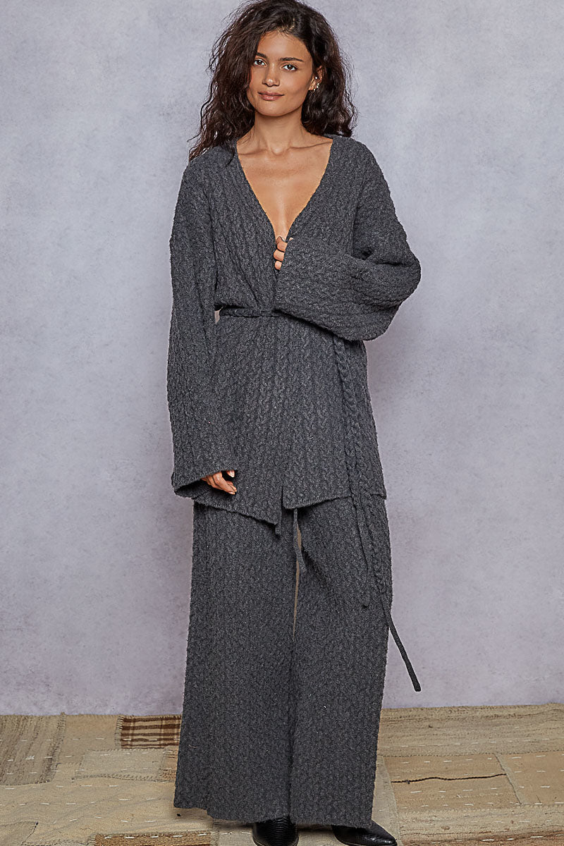 Woman wearing a gray textured outfit against a plain background