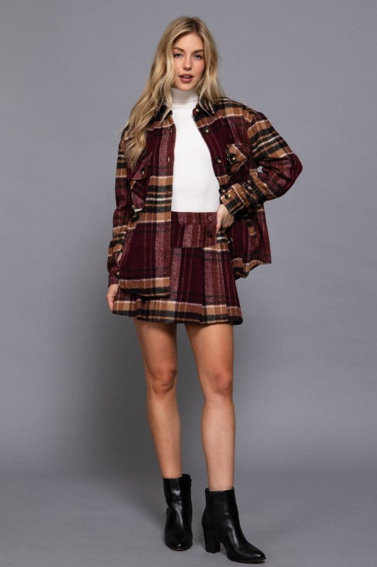 Woman wearing a plaid jacket and skirt set on a gray background