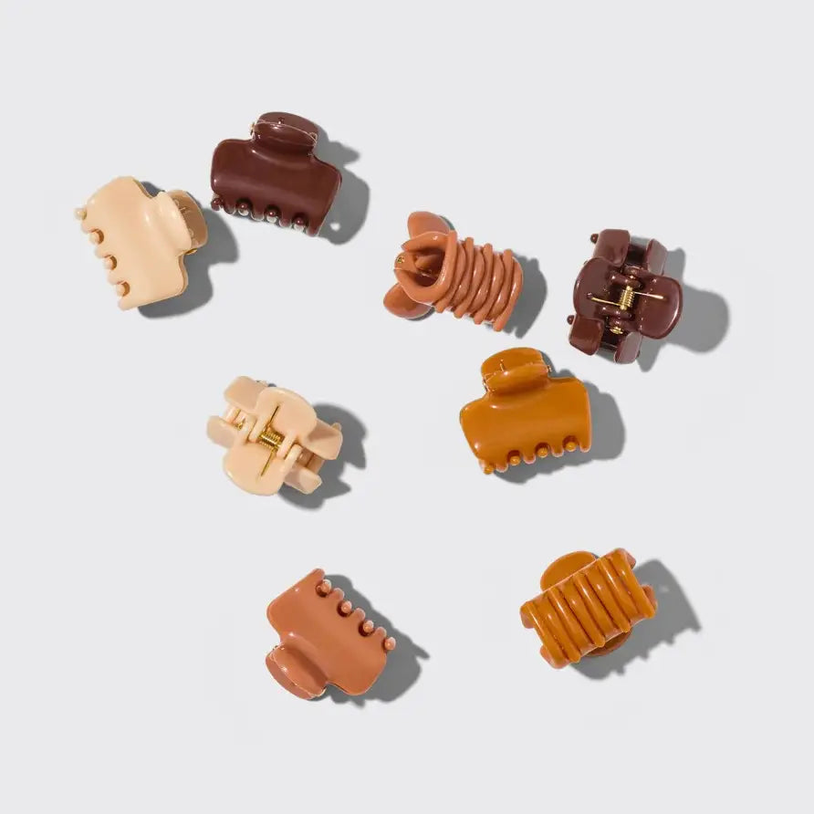 Set of nine hair clips in beige, brown, and orange on a light gray background
