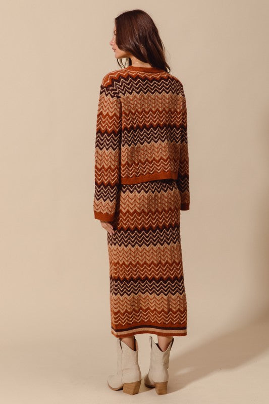 Woman wearing a long, patterned sweater against a beige background