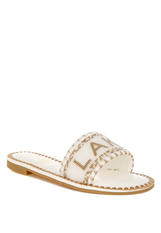 White sandal with brown accents on a white background