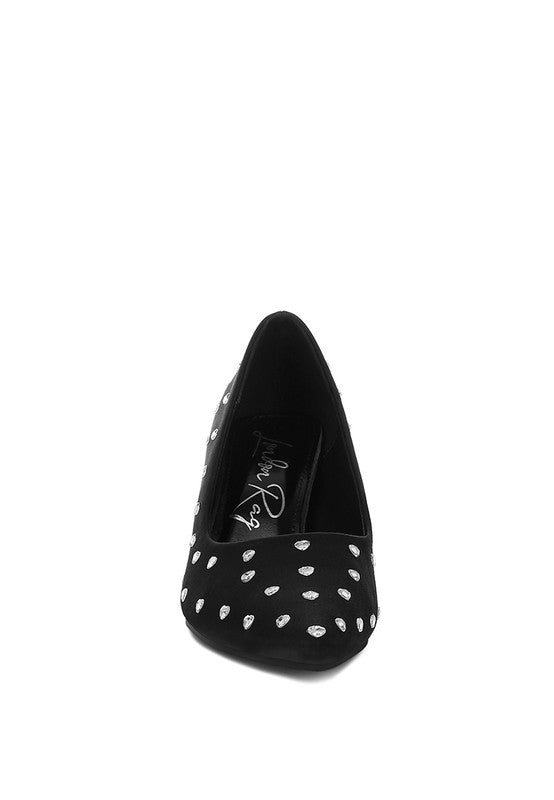Black high-heeled shoe with white polka dots on a white background