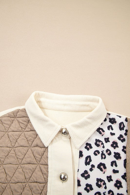 Close-up of a quilted vest with a white collar and leopard print pattern.