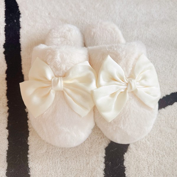 White fluffy slippers with large bows on a striped background