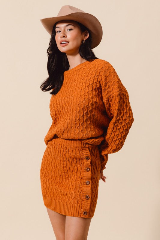 Woman wearing an orange knitted outfit with a hat on a beige background