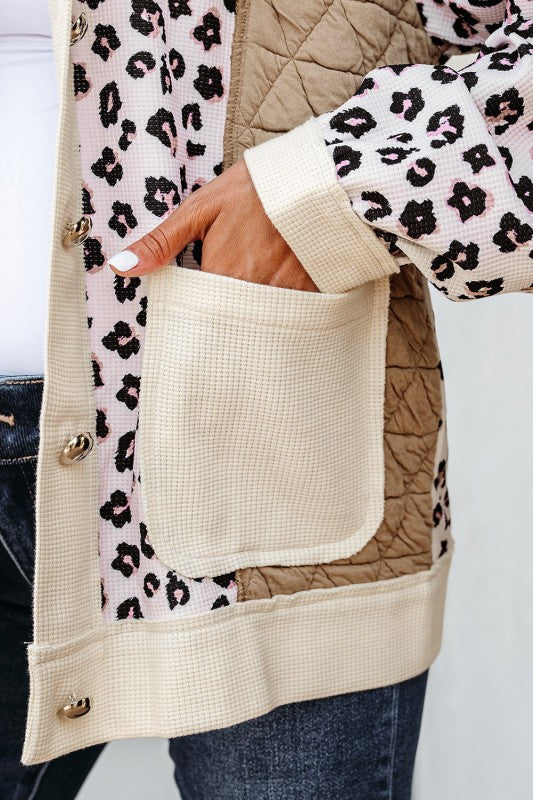 Beige quilted jacket with leopard print lining and cuffs on a white background