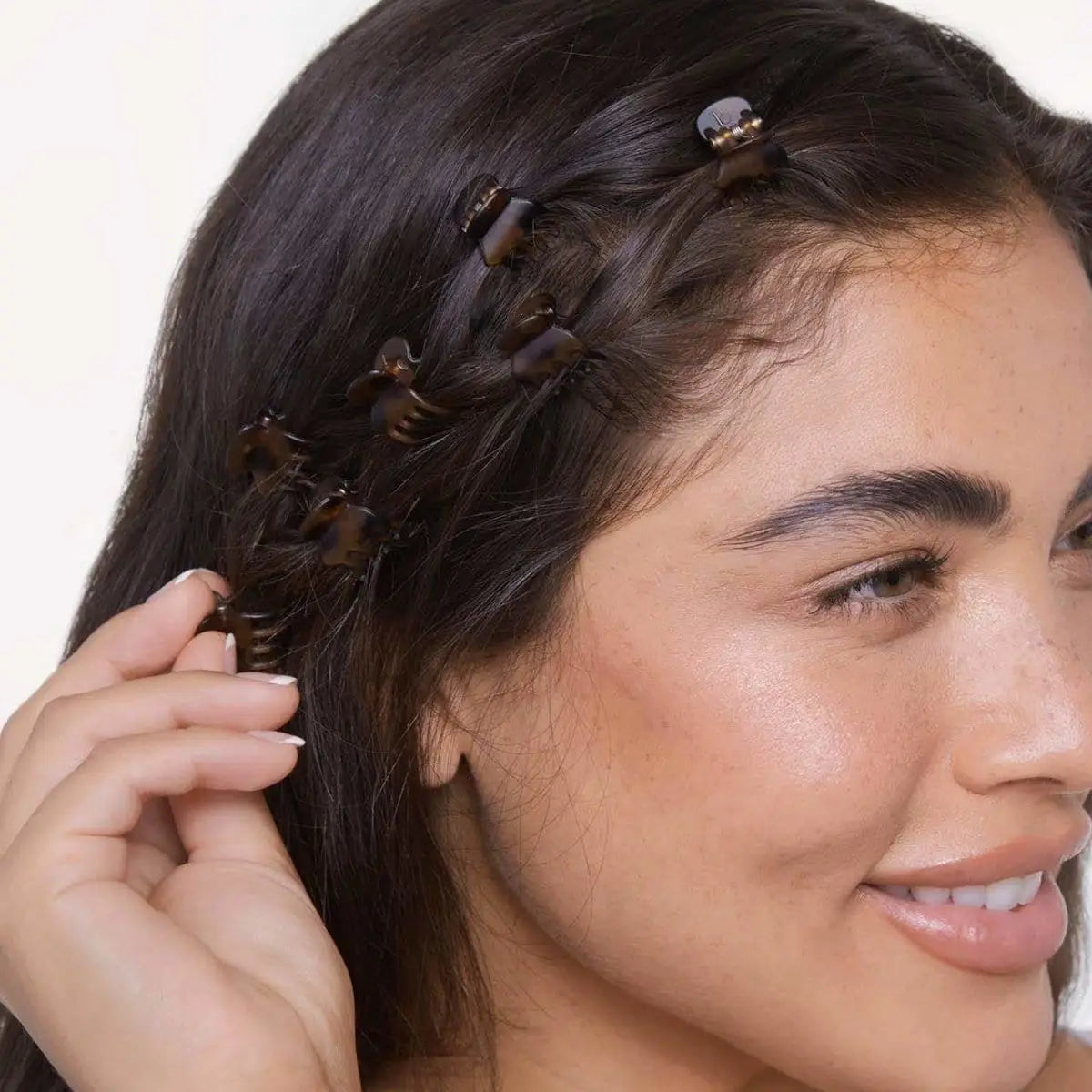 Woman with braided hair extensions styled in her hair against a neutral background
