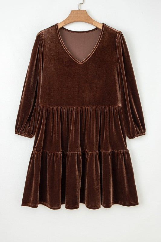 Brown velvet dress on a hanger against a white background