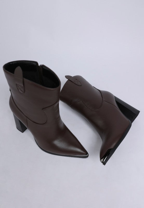 Pair of brown leather ankle boots on a light gray background
