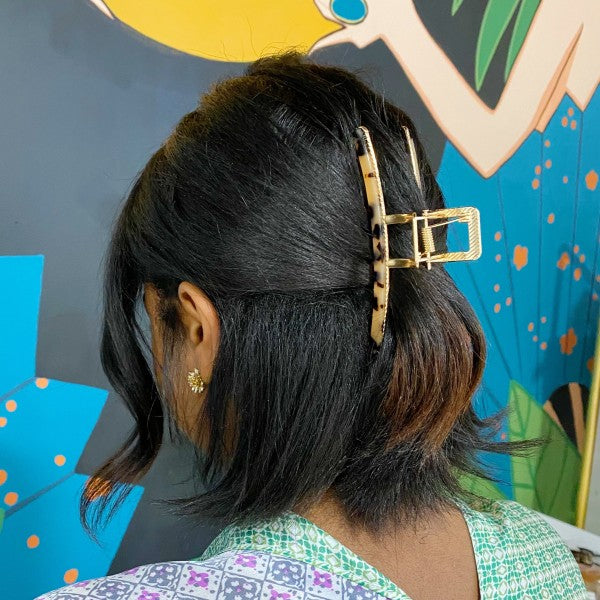 Person with a decorative hair clip against a colorful mural background