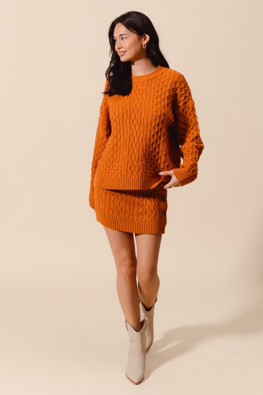 Woman wearing an orange knitted outfit with beige background