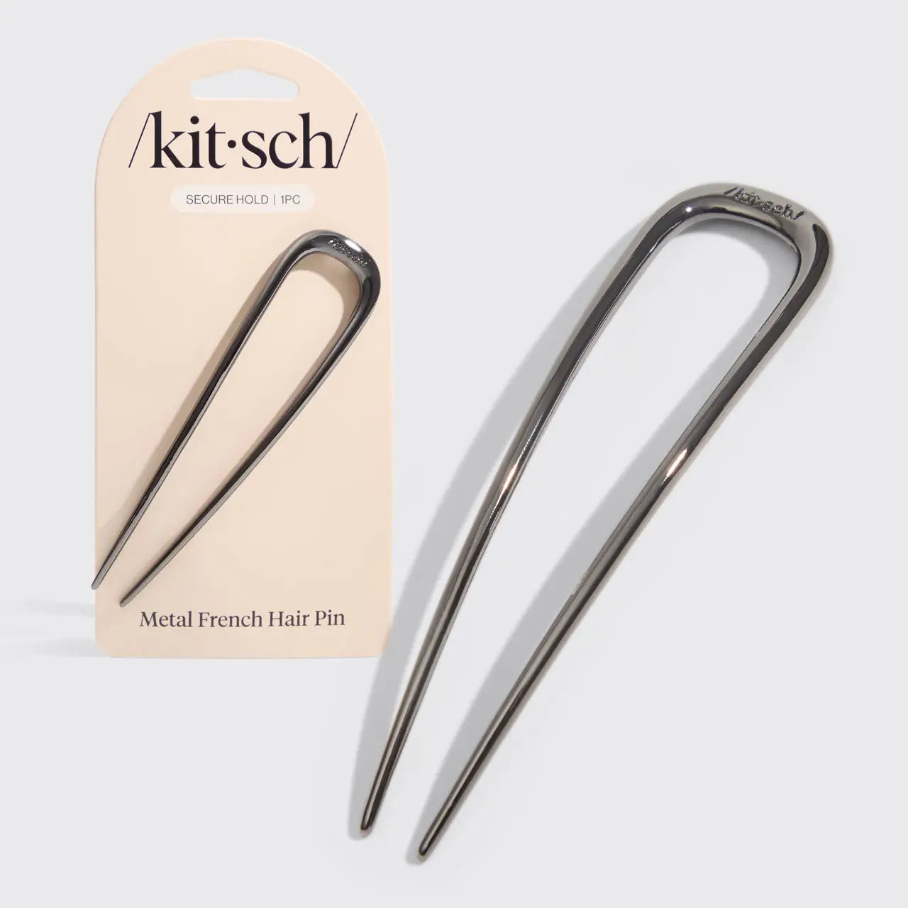 Metal French hair pin with packaging on a light gray background