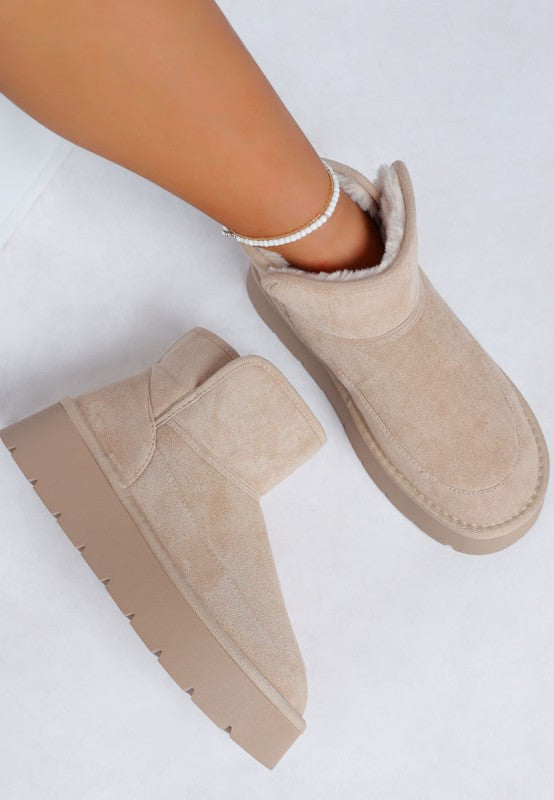 Beige suede ankle boots on a white background