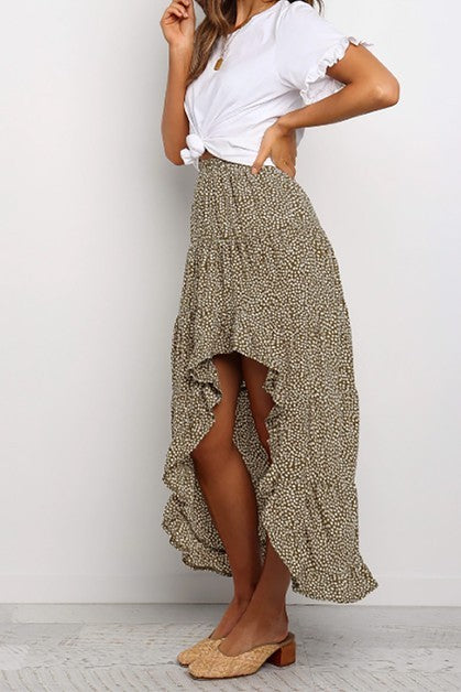 Woman wearing a white top and patterned skirt on a plain background