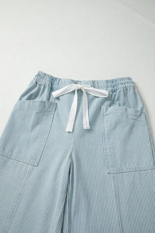 Light blue striped pants with a white drawstring on a light gray background