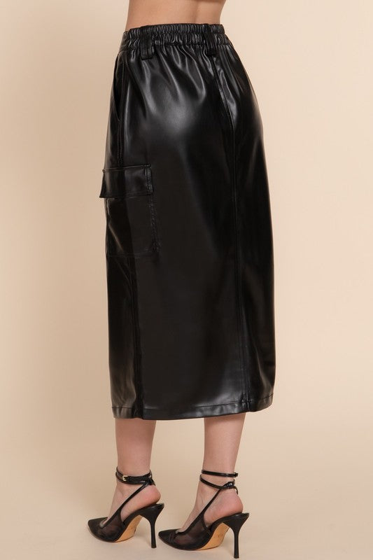 Black leather skirt worn by a person on a beige background
