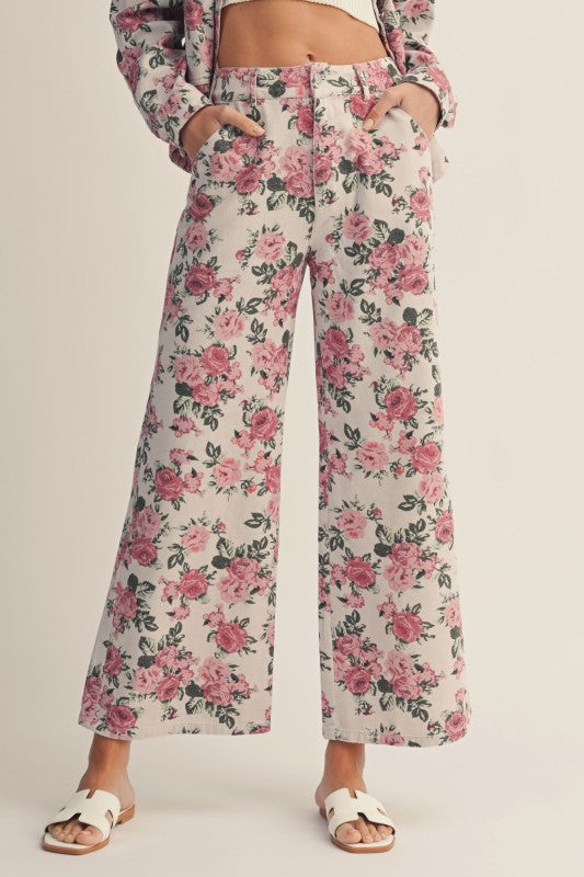 Floral pants worn by a person on a plain background