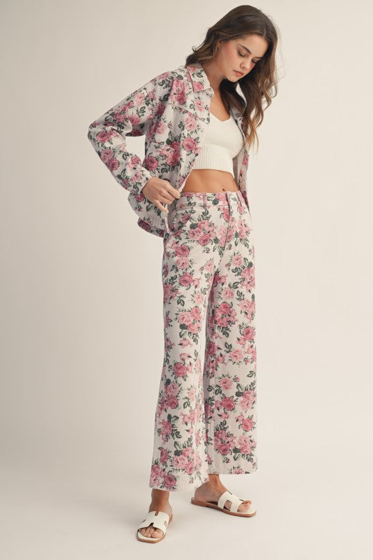 Woman wearing a floral two-piece suit on a plain background