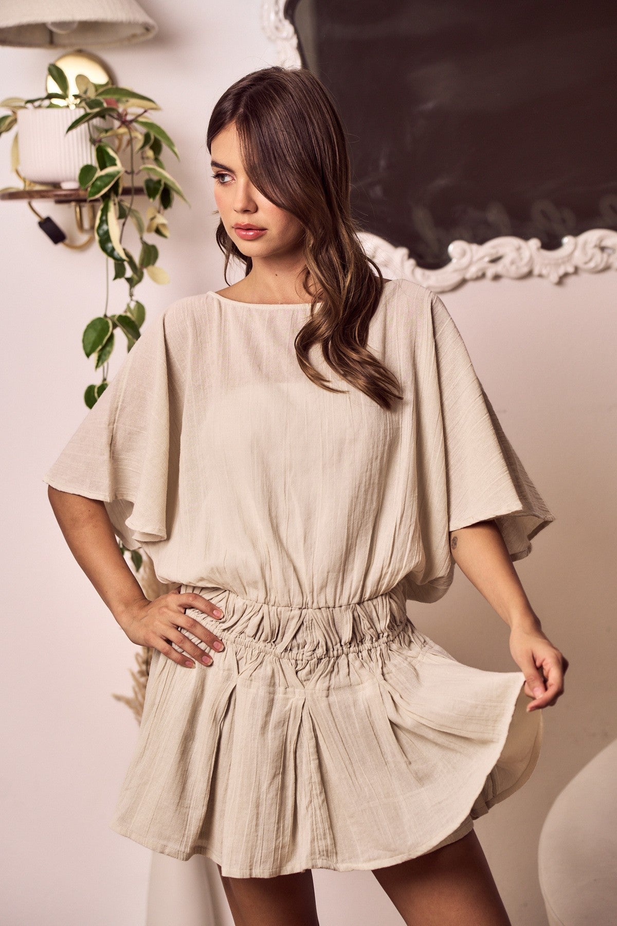 Woman wearing a beige dress with a soft background