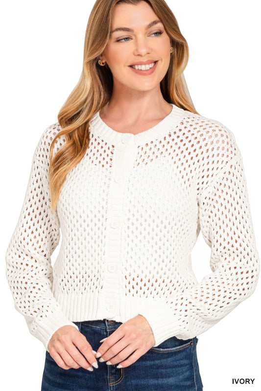 Woman wearing a white open-knit sweater against a white background