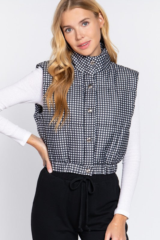 Black and white cropped fit puffer vest with snap closures and stretchy waistband.