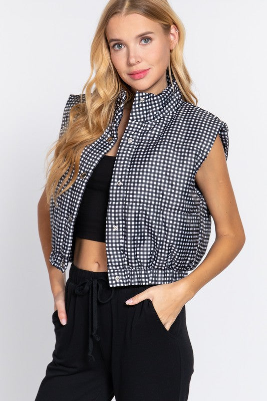 Black and white cropped fit puffer vest with snap closures and stretchy waistband.